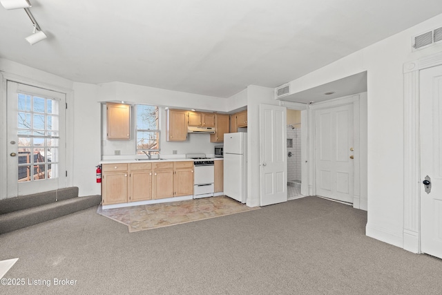 kitchen with white appliances, light colored carpet, visible vents, and under cabinet range hood