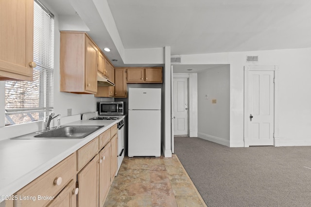 kitchen featuring visible vents, under cabinet range hood, light countertops, white appliances, and a sink