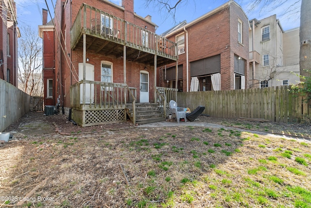 rear view of house featuring brick siding, central AC unit, a porch, and fence