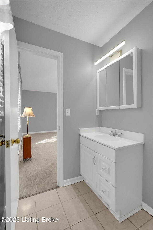 bathroom with tile patterned floors, baseboards, a textured ceiling, and vanity