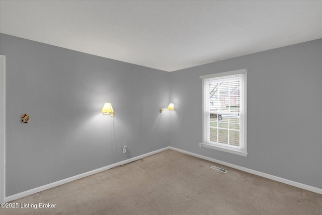 spare room with visible vents, baseboards, and carpet flooring