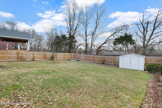 view of yard featuring an outdoor structure, a fenced backyard, and a shed