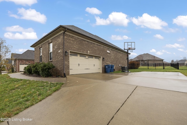 view of property exterior featuring fence, concrete driveway, central air condition unit, a lawn, and brick siding