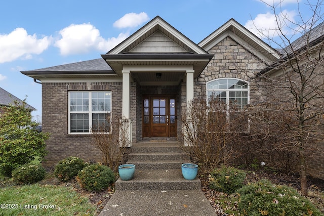 entrance to property with brick siding, stone siding, and roof with shingles