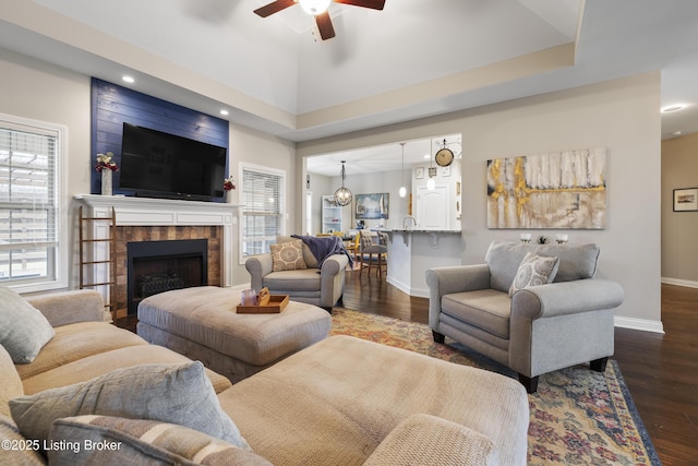 living area featuring ceiling fan, baseboards, recessed lighting, a fireplace, and wood finished floors