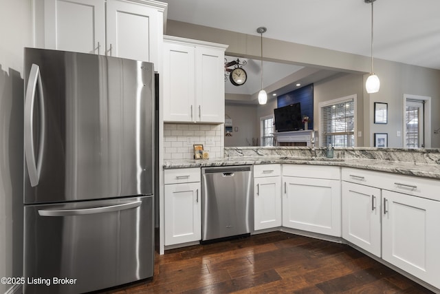 kitchen with tasteful backsplash, dark wood-type flooring, light stone counters, stainless steel appliances, and a sink