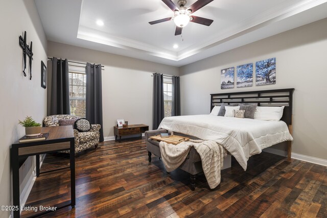 bedroom with recessed lighting, baseboards, a tray ceiling, and wood-type flooring