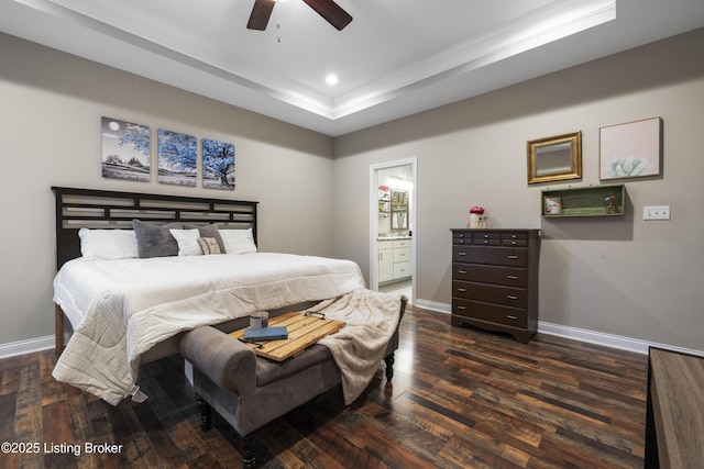 bedroom featuring connected bathroom, dark wood-type flooring, baseboards, recessed lighting, and a raised ceiling