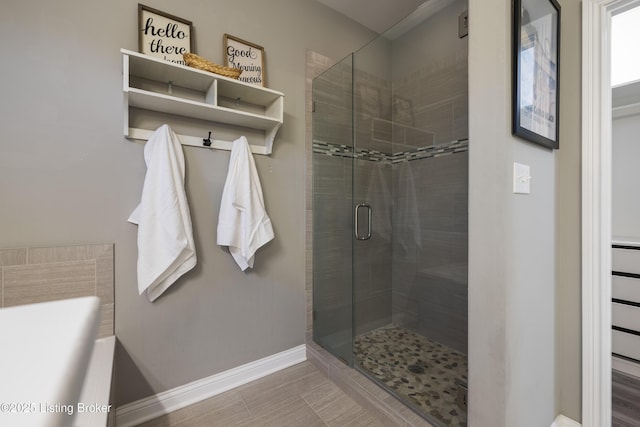 bathroom featuring baseboards and a shower stall