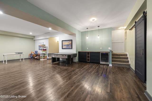 interior space featuring a barn door, recessed lighting, wood finished floors, and visible vents