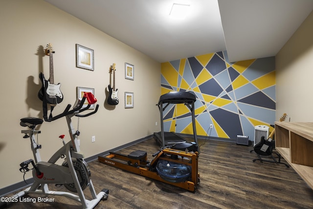 exercise area with baseboards, wood finished floors, an accent wall, and wallpapered walls