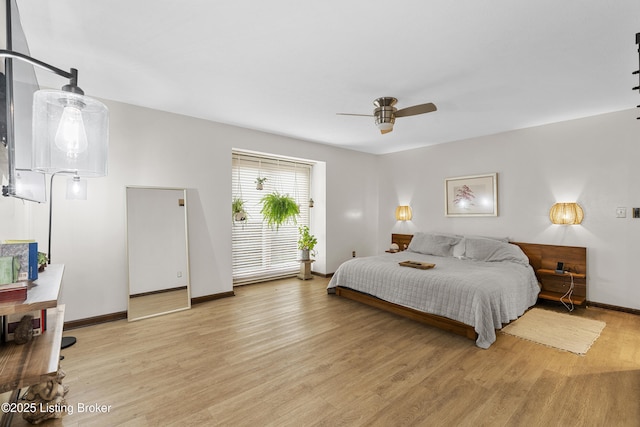 bedroom with baseboards, light wood-style floors, and a ceiling fan