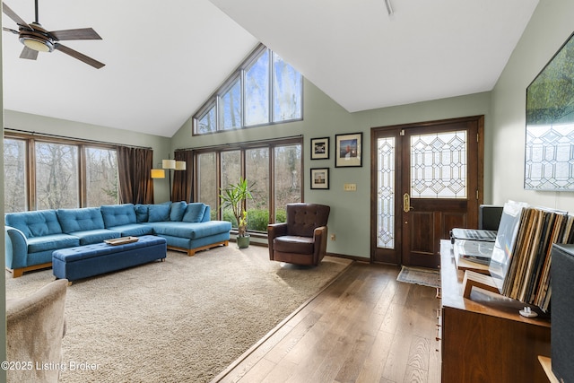 living room with a ceiling fan, a healthy amount of sunlight, wood-type flooring, and high vaulted ceiling