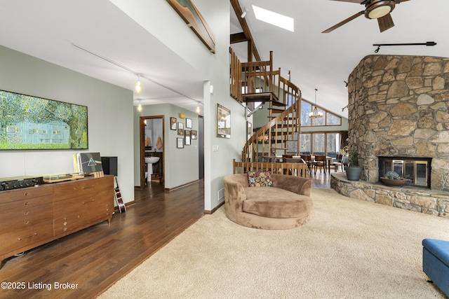 living room featuring stairway, wood finished floors, track lighting, and a ceiling fan