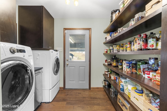 laundry room with laundry area, wood finished floors, and washing machine and dryer