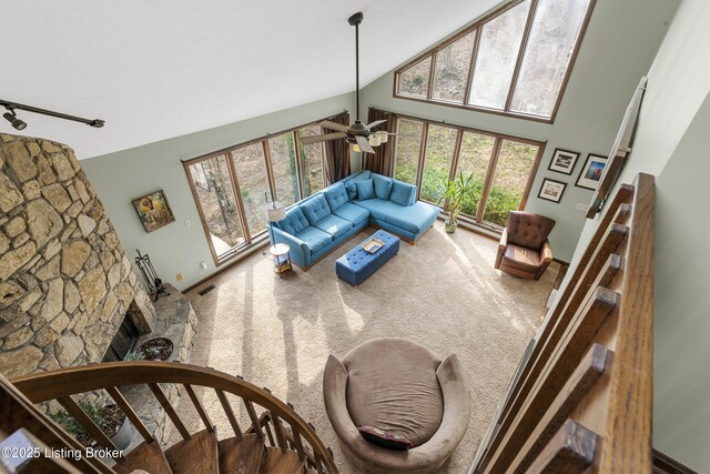 carpeted living area featuring rail lighting, a ceiling fan, visible vents, and high vaulted ceiling