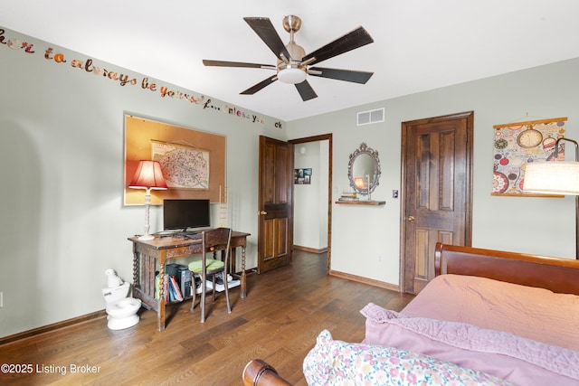 bedroom featuring visible vents, a ceiling fan, baseboards, and wood finished floors