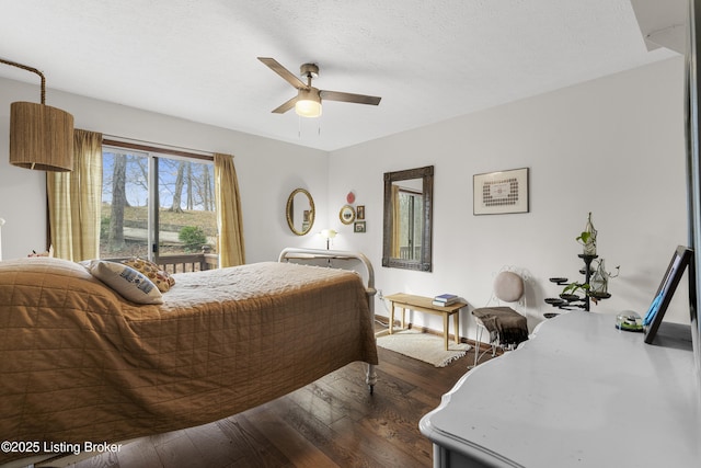 bedroom featuring dark wood finished floors, a ceiling fan, baseboards, and a textured ceiling