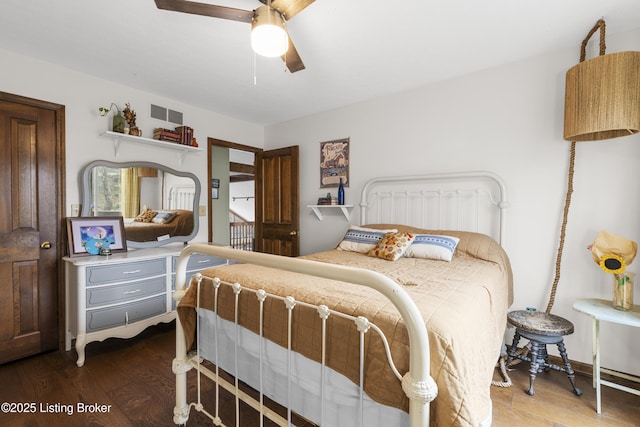 bedroom with ceiling fan, visible vents, and wood finished floors