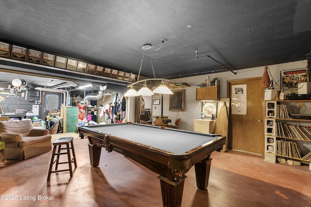 recreation room with pool table, a textured ceiling, and finished concrete floors