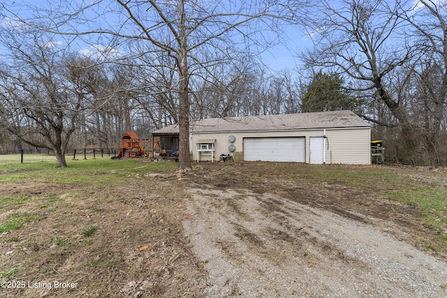 view of front of property with a playground, fence, a garage, and driveway