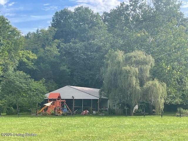 view of yard featuring a forest view and a playground