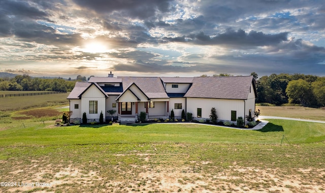 modern inspired farmhouse featuring a chimney, a yard, and a shingled roof