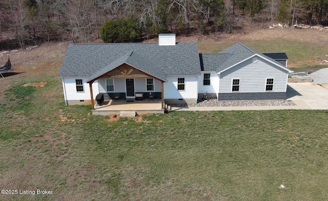 exterior space featuring a front lawn, a trampoline, a chimney, crawl space, and a patio