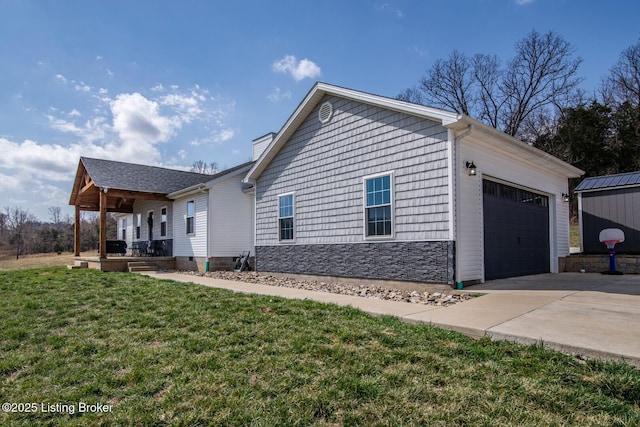 view of property exterior with an attached garage, a yard, covered porch, a chimney, and concrete driveway