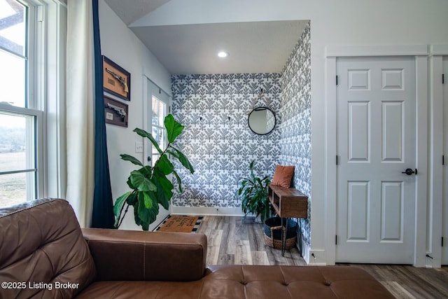 interior space featuring an accent wall, plenty of natural light, and wood finished floors