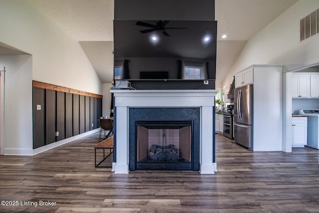 room details with visible vents, washer / dryer, freestanding refrigerator, wood finished floors, and a ceiling fan