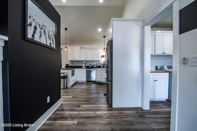 kitchen featuring dark countertops, white cabinets, dark wood-style flooring, and appliances with stainless steel finishes