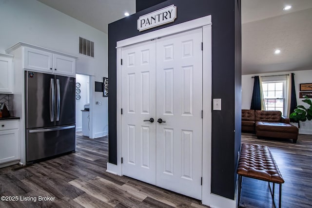 kitchen with visible vents, white cabinetry, dark wood finished floors, and freestanding refrigerator