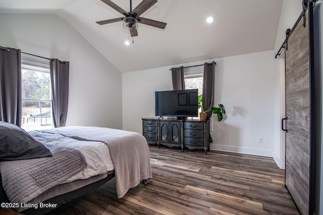 bedroom featuring baseboards, dark wood-style flooring, ceiling fan, vaulted ceiling, and a barn door