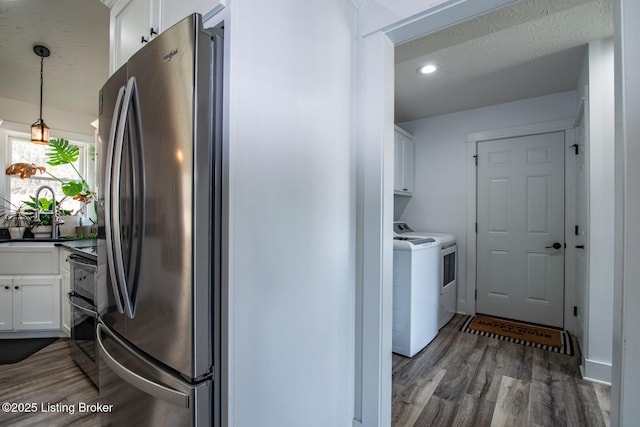 washroom featuring wood finished floors, recessed lighting, cabinet space, a textured ceiling, and washer and dryer