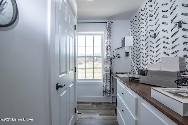 bathroom with baseboards, plenty of natural light, wood finished floors, and vanity