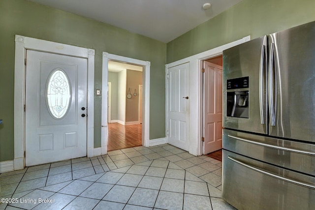 foyer entrance featuring light tile patterned floors and baseboards