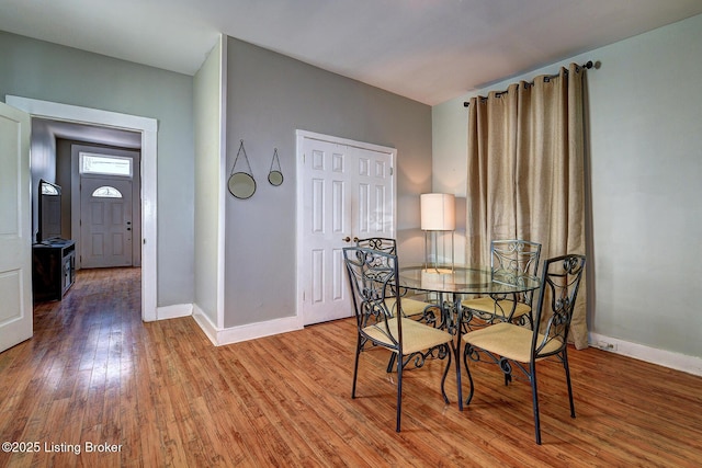 dining space with hardwood / wood-style floors and baseboards