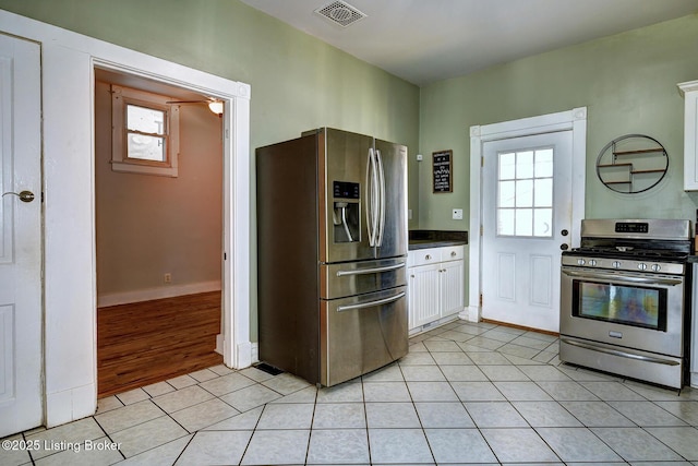 kitchen featuring a wealth of natural light, visible vents, appliances with stainless steel finishes, light tile patterned flooring, and white cabinets