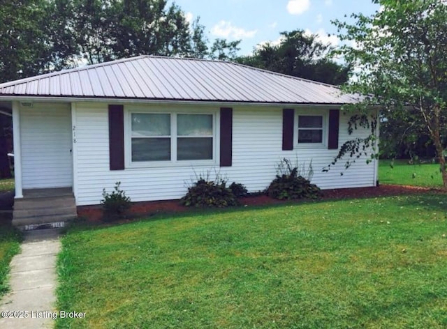 view of front of property featuring metal roof and a front yard