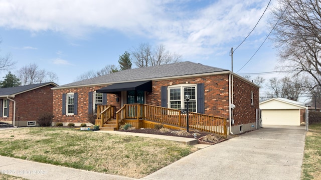 view of front of house with brick siding, a front lawn, a detached garage, and an outdoor structure