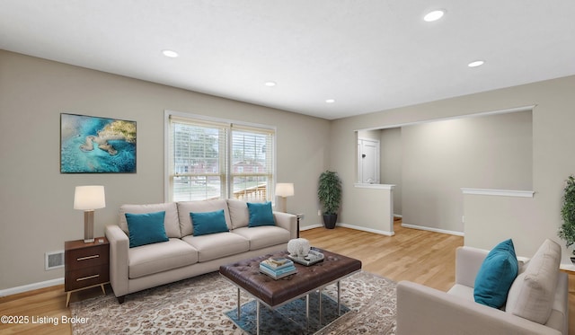 living area with light wood-style flooring, recessed lighting, visible vents, and baseboards