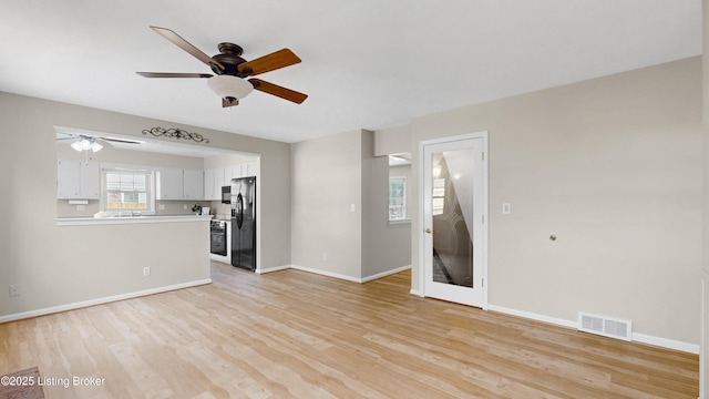 unfurnished living room with visible vents, baseboards, light wood-type flooring, and a ceiling fan