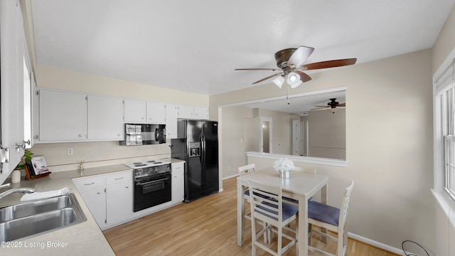 kitchen with ceiling fan, light countertops, light wood-style floors, black appliances, and a sink