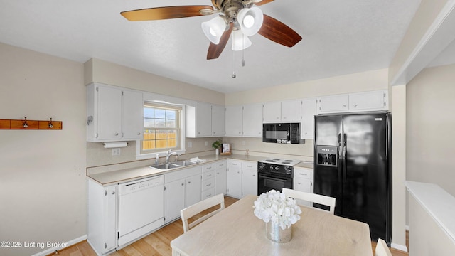 kitchen featuring ceiling fan, a sink, black appliances, white cabinets, and light countertops