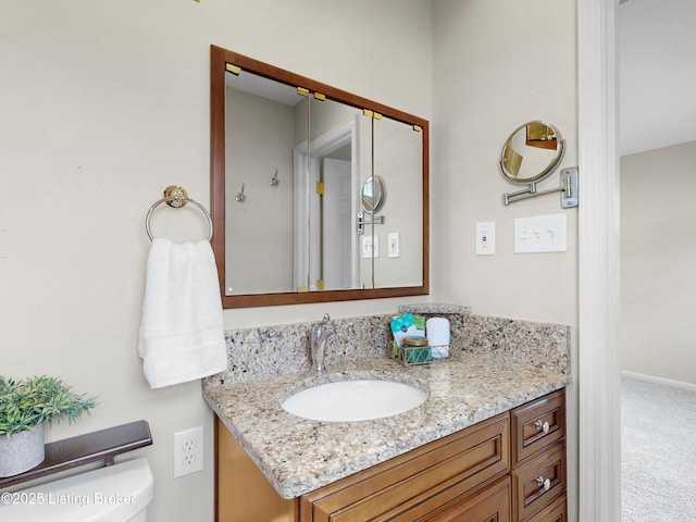 half bath with baseboards, toilet, and vanity