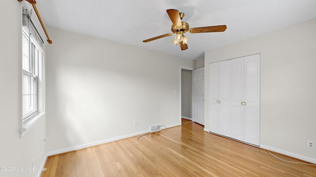 unfurnished bedroom with visible vents, baseboards, a closet, and light wood finished floors