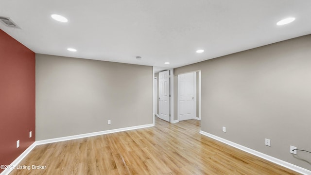 unfurnished room featuring baseboards, visible vents, and light wood-type flooring