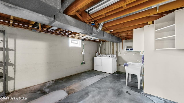 below grade area with a sink and washer and clothes dryer