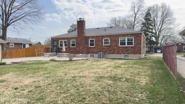 rear view of house featuring a yard, brick siding, fence private yard, and a patio area